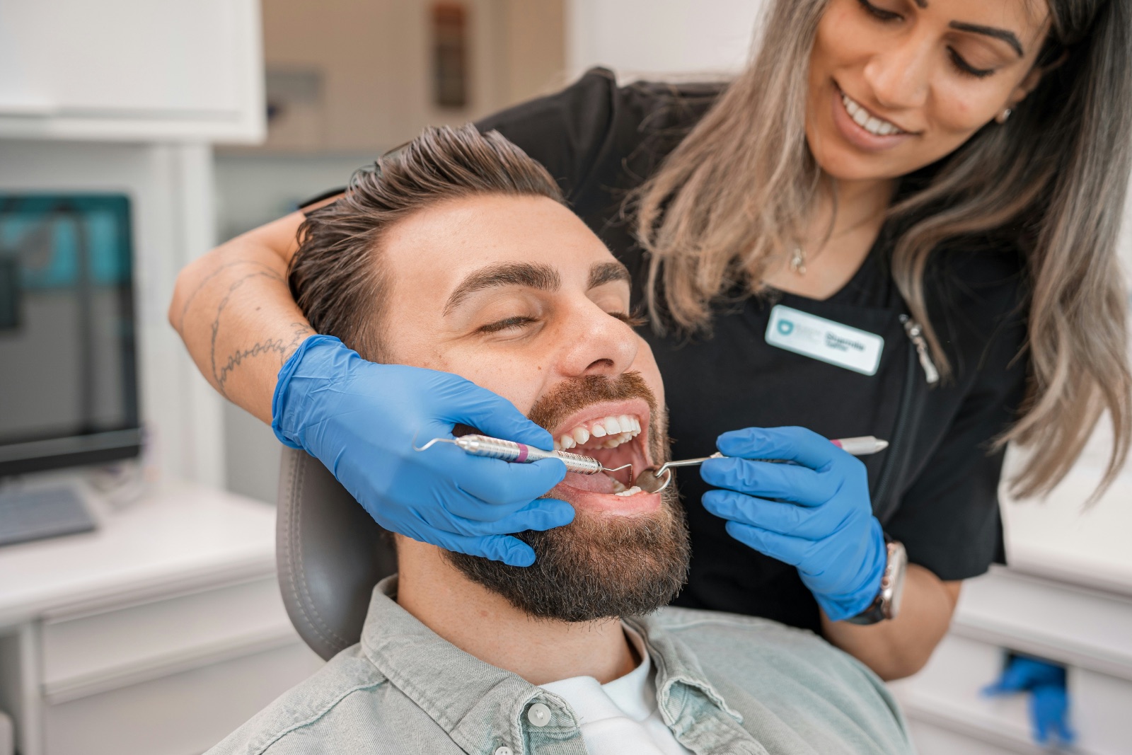 A calm dental reception inside the Auckland Airport Shopping Centre with a family checking in at the desk
